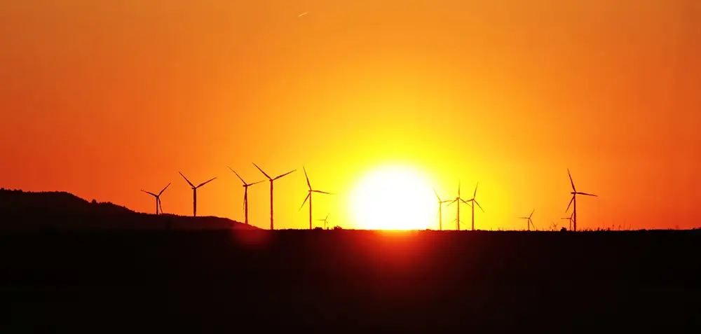 Forte chaleur paysage avec éoliennes au coucher du soleil