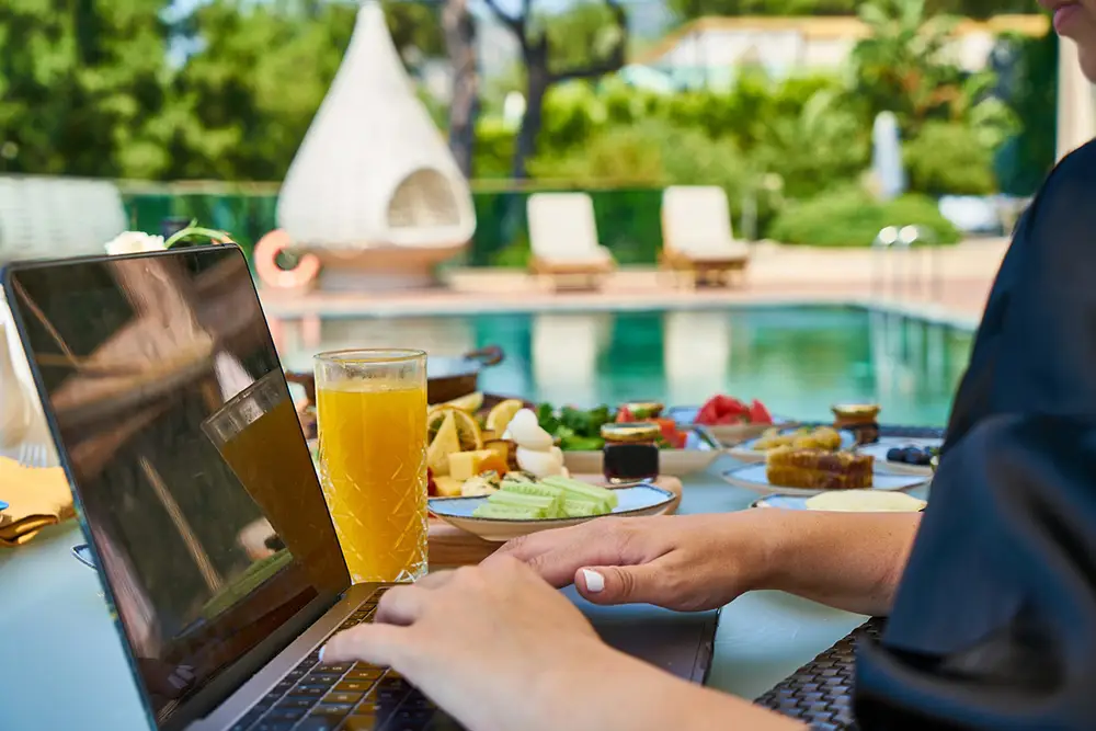 freelancing - Personne travaillant sur son ordinateur au bord d'une piscine