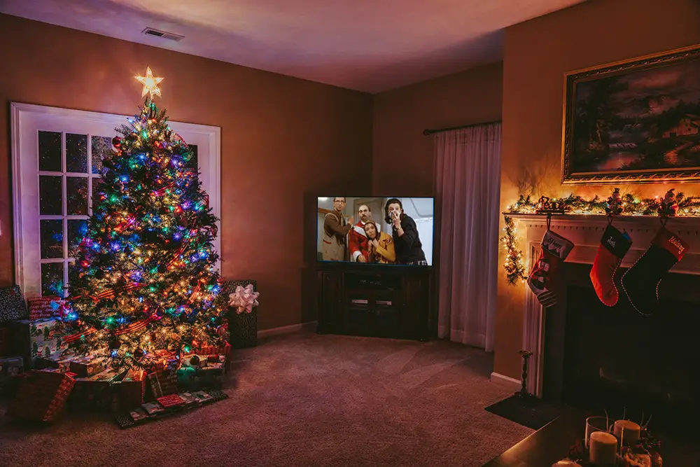 Salon avec décorations des fêtes et tv qui passe des films du cinéma français