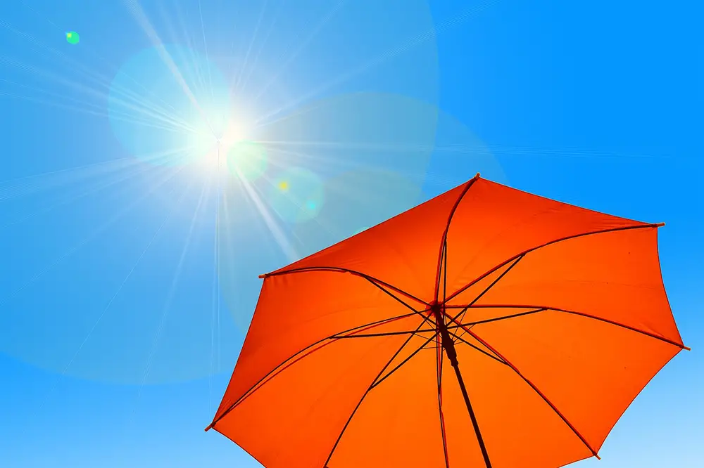 Parasol orange en été : Se protéger des rayons UV